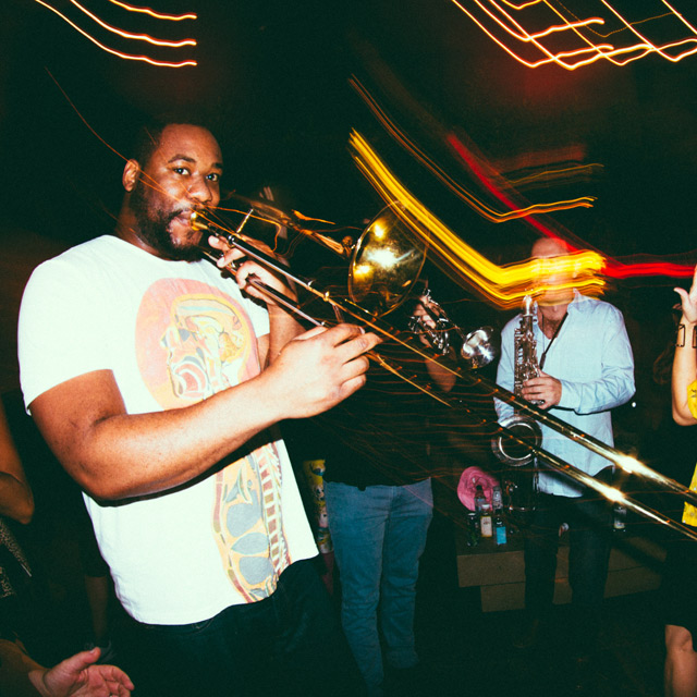 man playing a trombone in a club