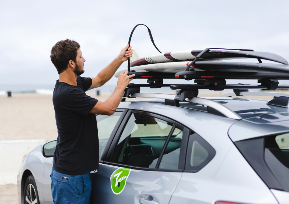 man with surfboards on car