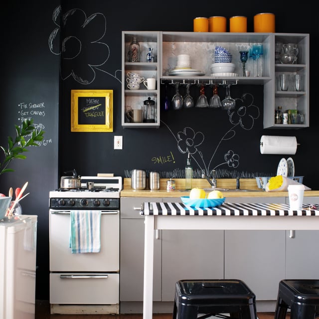 a modern kitchen with black walls and white cabinets