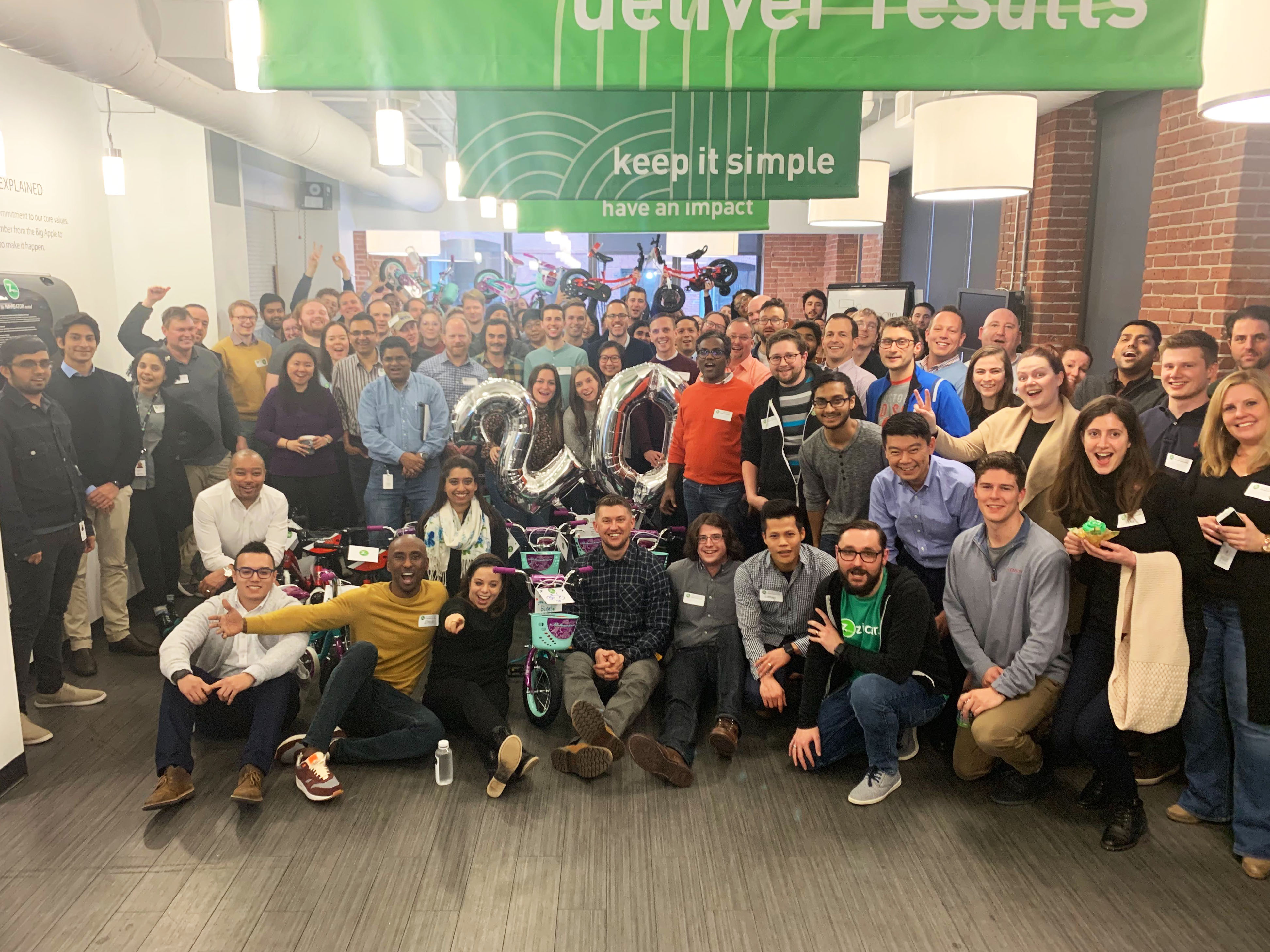 Group shot of Zipcar employees in large space with bicycles