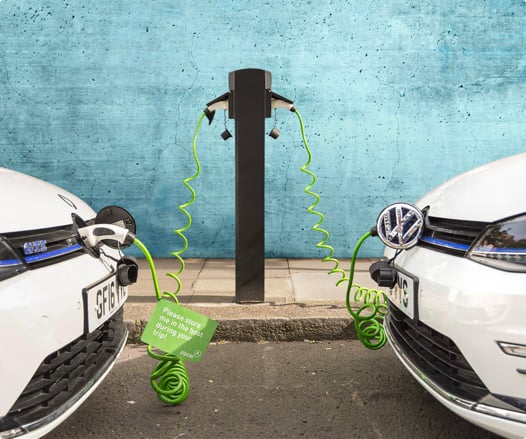 two electrical cars plugged in and charging