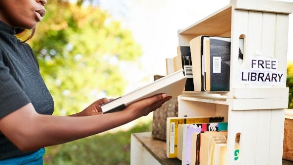 Woman taking a book from a free library