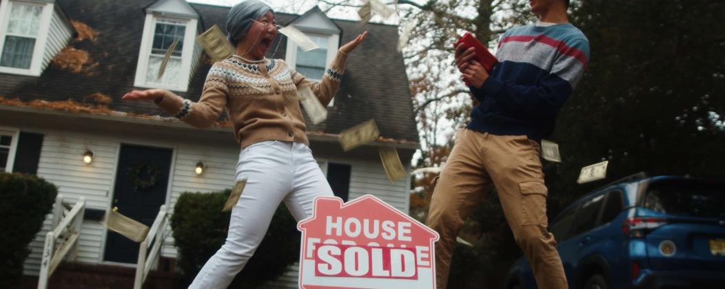 man and woman next to a sold sign
